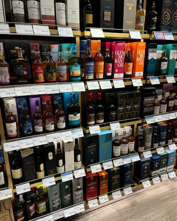 The wider malt whisky wall in Istanbul departures, with competitor brands on multiple shelves